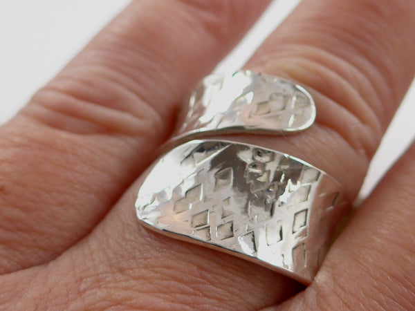Brede zilveren, open ring met reliëf en anticlastisch gesmeed