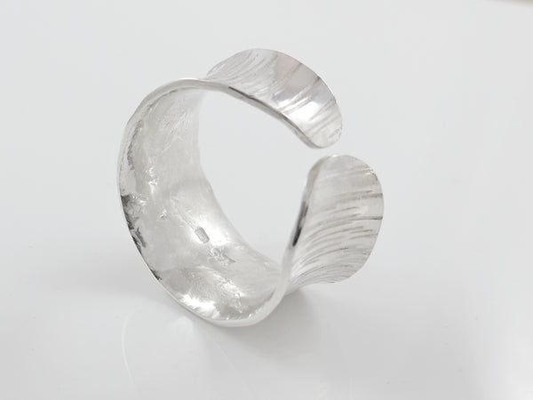 Brede zilveren, open ring met reliëf en anticlastisch gesmeed