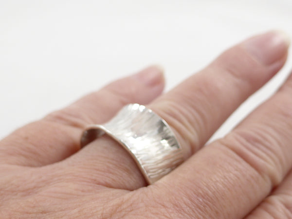 Brede zilveren, open ring met reliëf en anticlastisch gesmeed