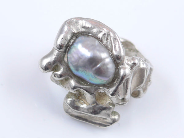 Een flinke, stoere ring aan je hand met daarop een prachtig warmglanzende, blauwgrijze barokke zoetwaterparel is altijd iets bijzonders. De ring is gegoten en daardoor massief maar toch niet zwaar. De vorm is organisch en vloeiend. 
