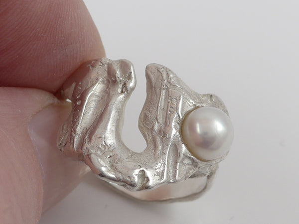 Deze zilveren ring is gegoten via een speciale zogenaamde Verloren-was-methode en heeft zo een organische vorm gekregen. De witte, zacht glanzende zoetwater parel zorgt voor een bijzondere uitstraling. Deze ring is opvallend uniek en heerlijk draagbaar bij vele outfits.