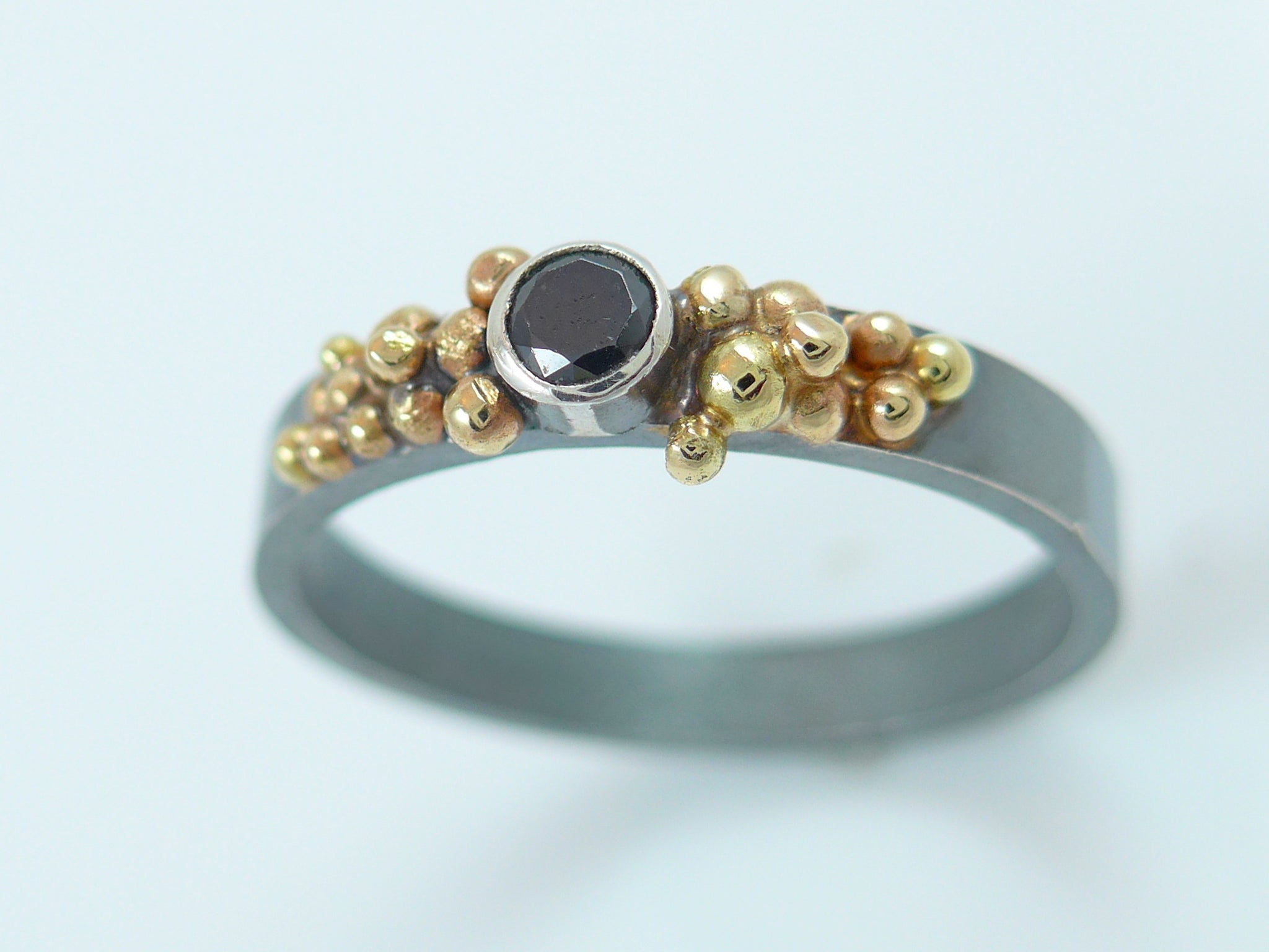 Zilveren ring met 14 karaat gouden granules en zwarte Zirconia