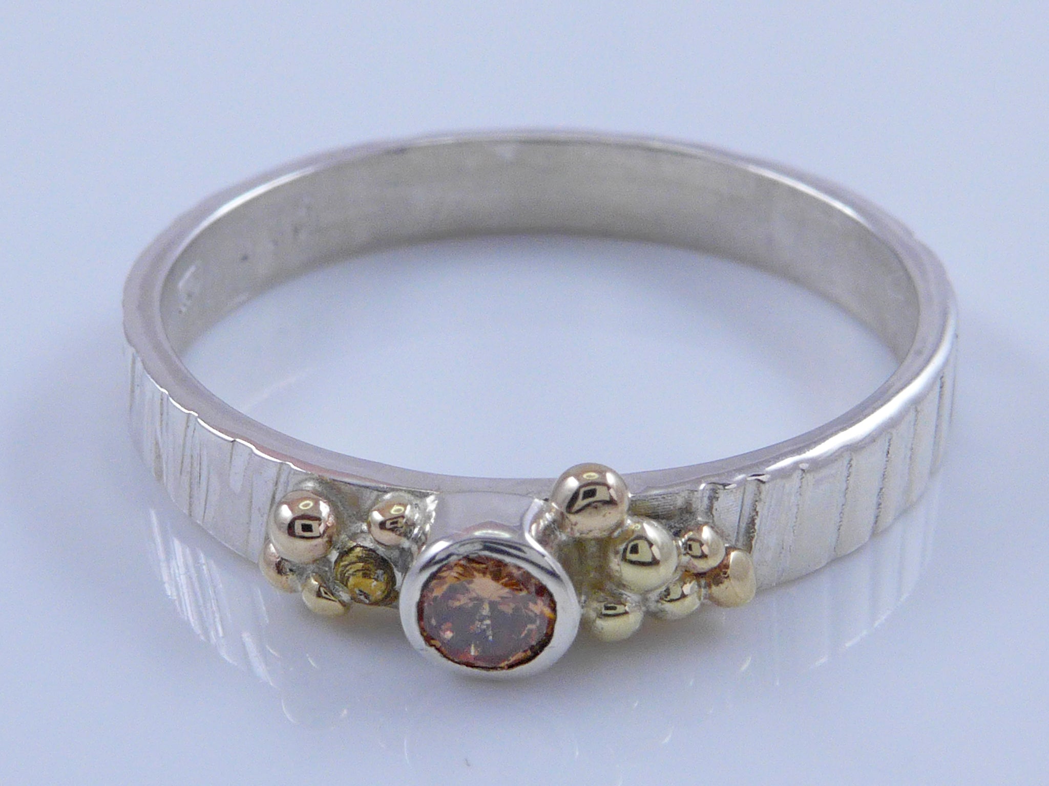 Zilveren ring met geelgouden granules en champagnekleurige Zirconia